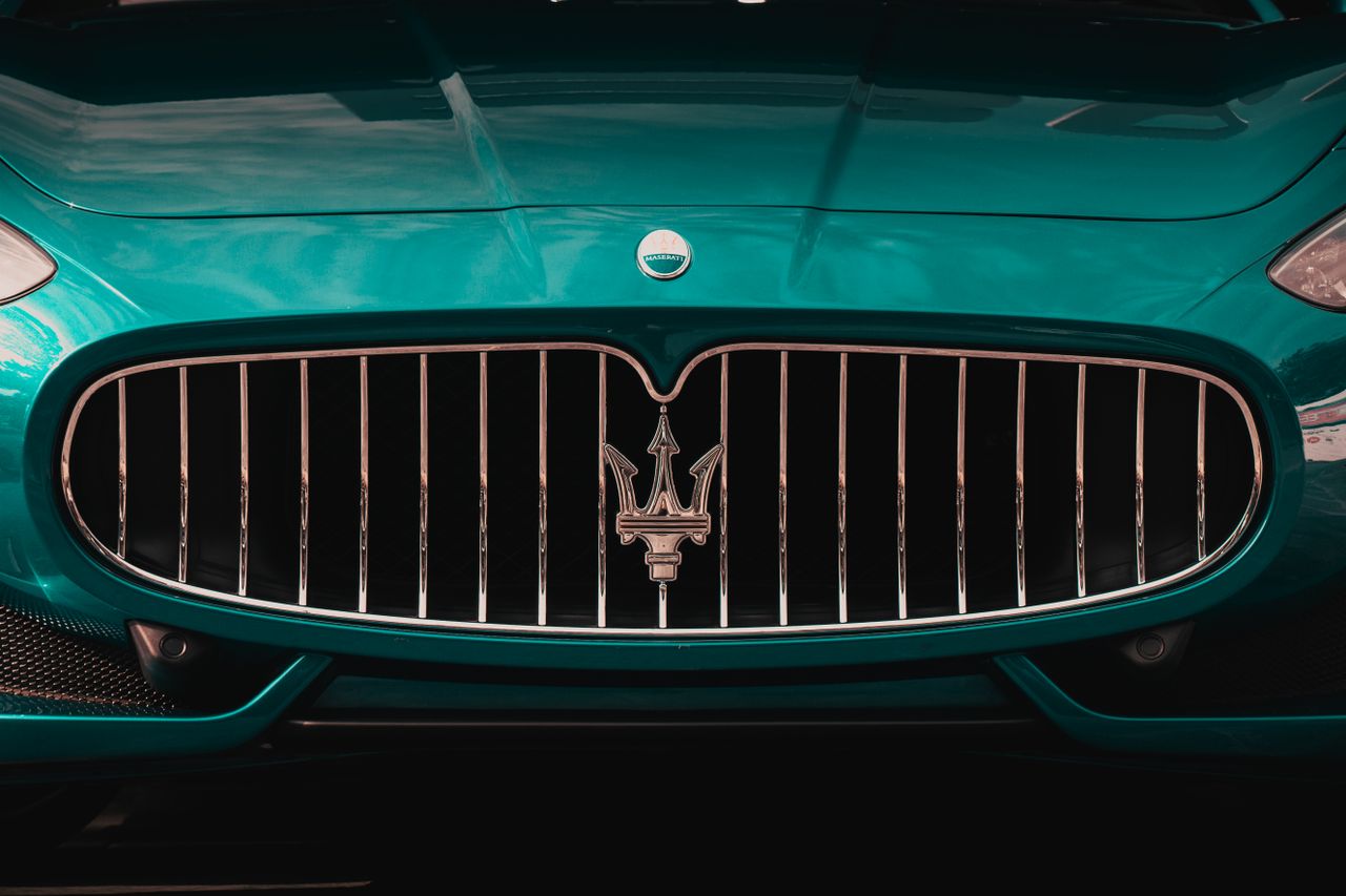 team-01 Close-up of a sleek Maserati car grille showcasing luxury and style.