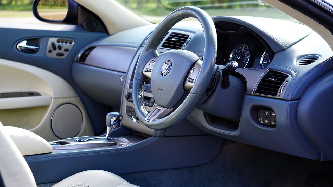 services-01 Elegant interior of luxury car featuring steering wheel and dashboard.